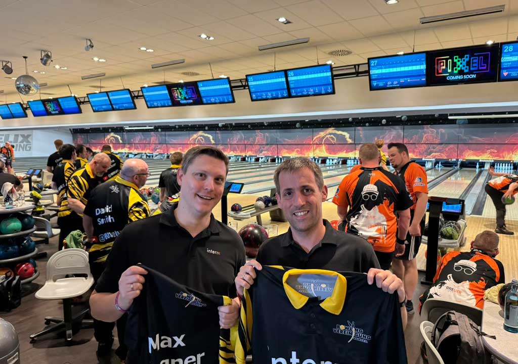 Das Bild zeigt die beiden Gesellschafter der Interix GmbH in einer Bowlinghalle (Ludwigshafen) mit dem aktuellen Team-Trikot in der Hand.